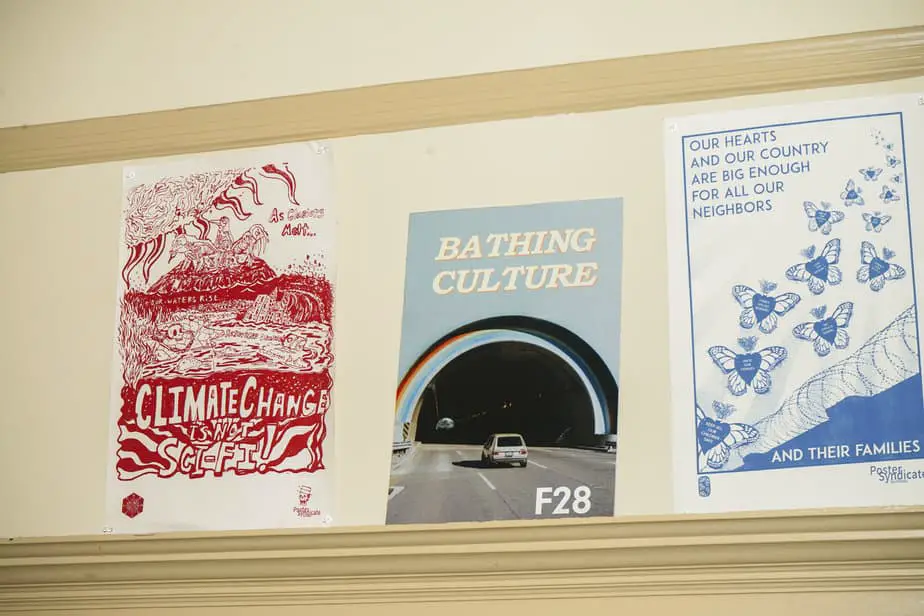 A Bathing Culture poster nestled between a climate change and border protest poster. Much of the culture they address through their product is about change and love in some capacity.
