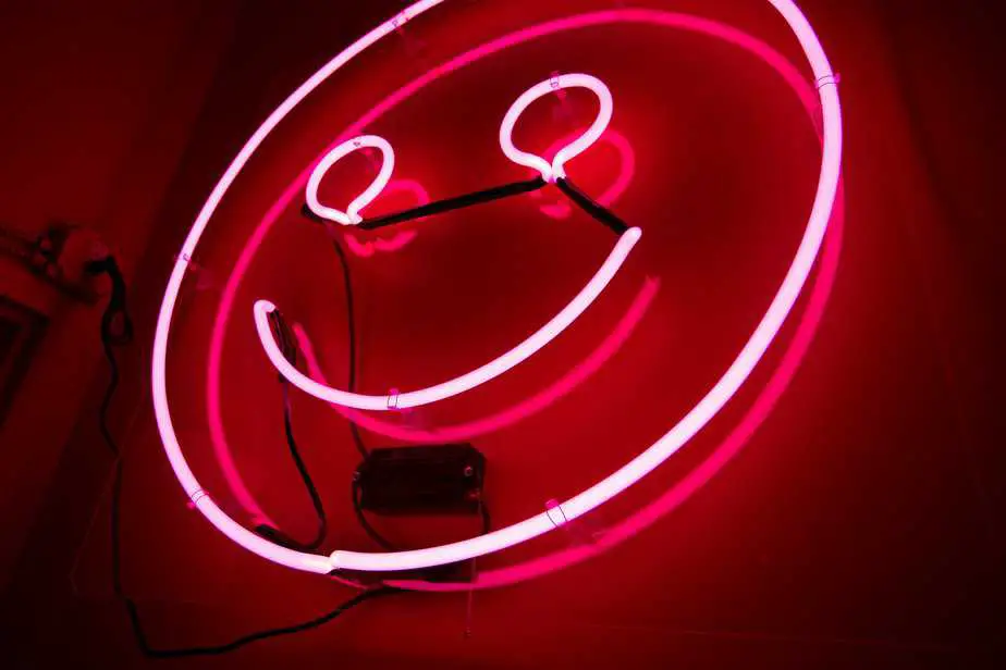 The neon happy sign in the stairwell of the Color Factory.